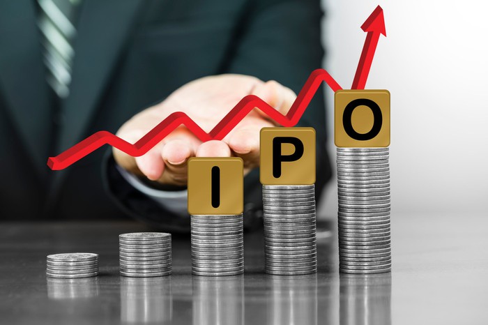 Blocks spelling 'IPO' on top of coin stacks.