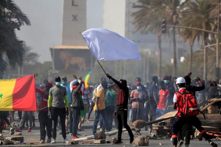 A supporter of opposition leader Ousmane Sonko holds a white flag during clashes with security forces in Dakar, Senegal March 8.